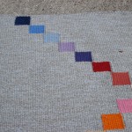 Shows more clearly the technique of using tapestry to insert the colour blocks on stepping stones rug